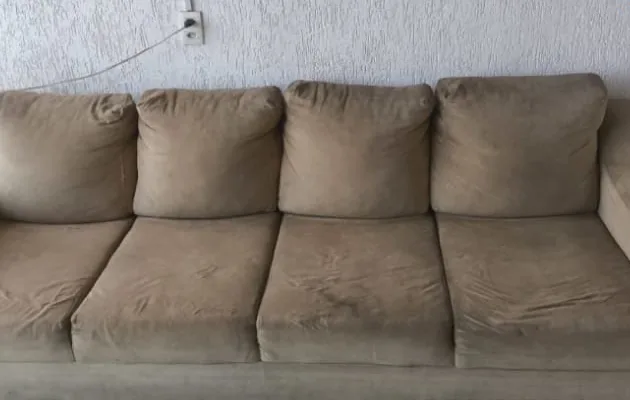 O mesmo sofá bege antes da higienização, com manchas nos assentos e braços